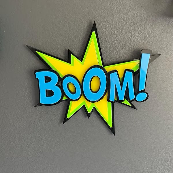 Colorful 'BOOM!' sign on a gray wall