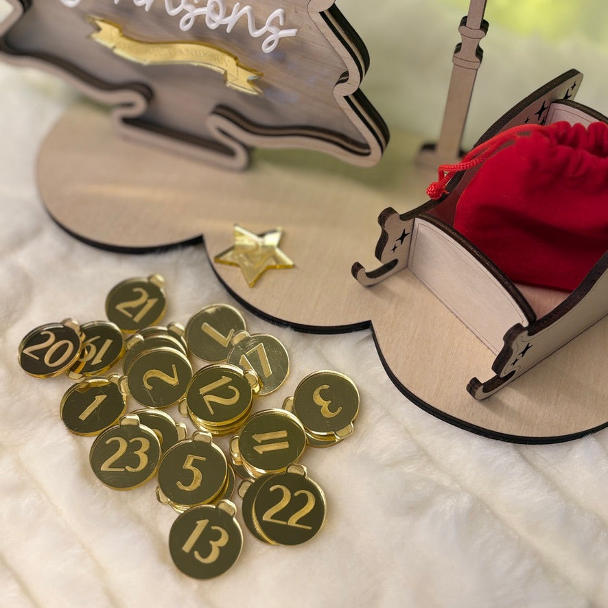 Gold number charms with a small bag and decorative item in the background.