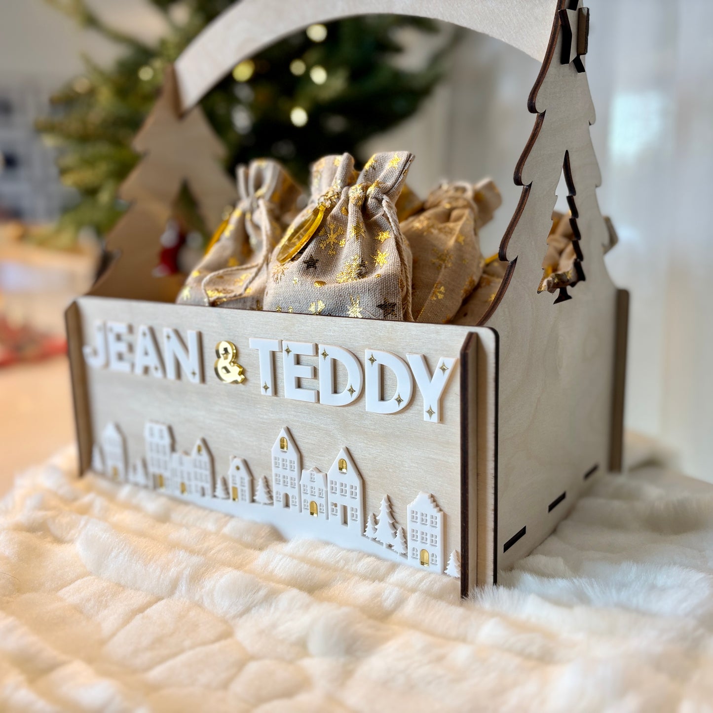 Wooden gift box with 'JEAN & TEDDY' and decorative bags on a soft surface.