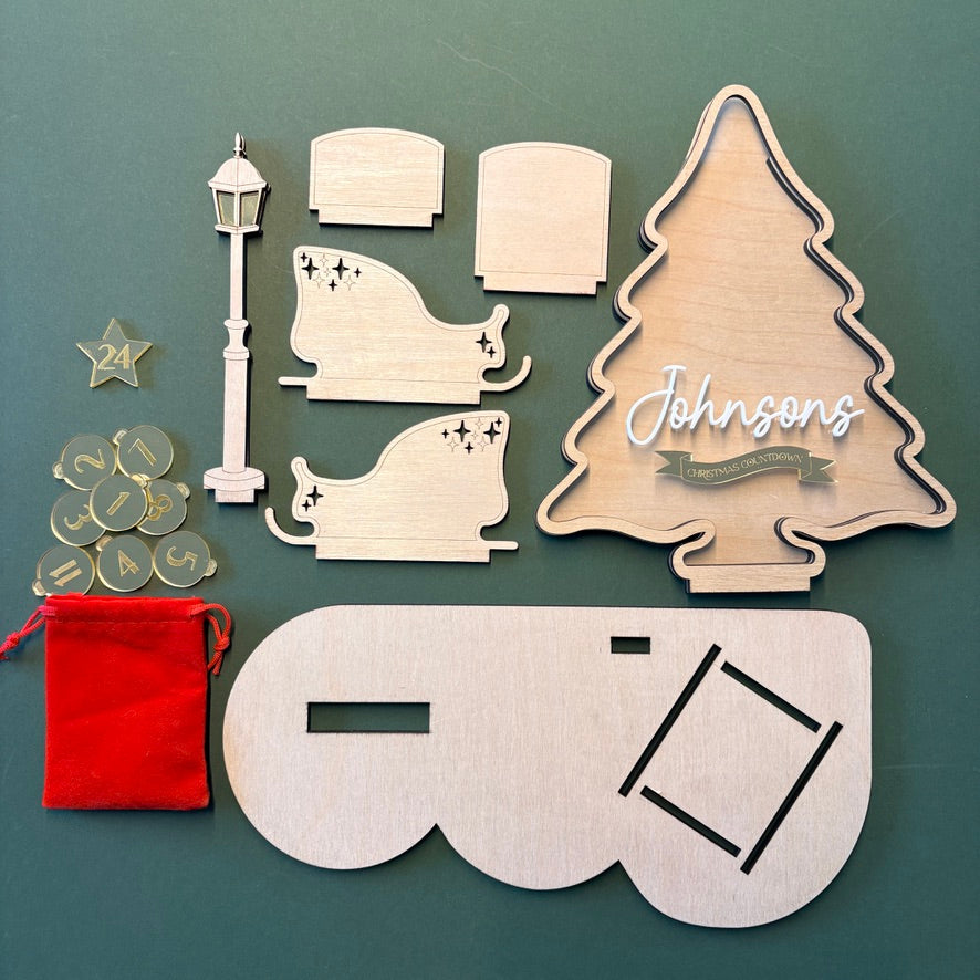Set of wooden Christmas-themed decorations flat packed on a green background