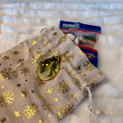 Decorative bag with gold snowflake patterns on a textured white surface