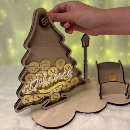 Wooden Christmas tree-shaped calendar with numbers and letters, coins being inserted into Christmas tree 