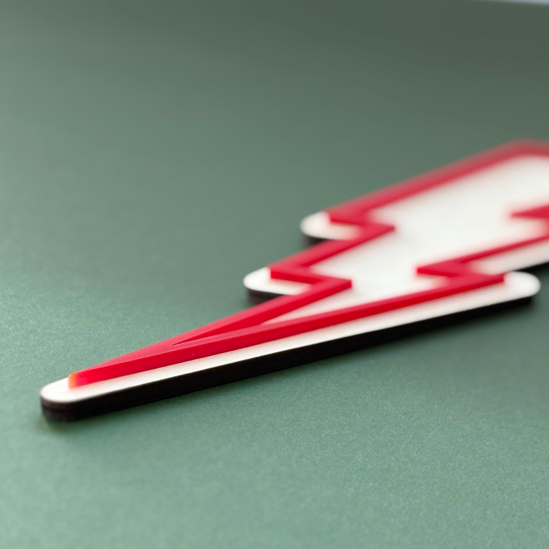 Red and white lightning bolt symbol on a green surface